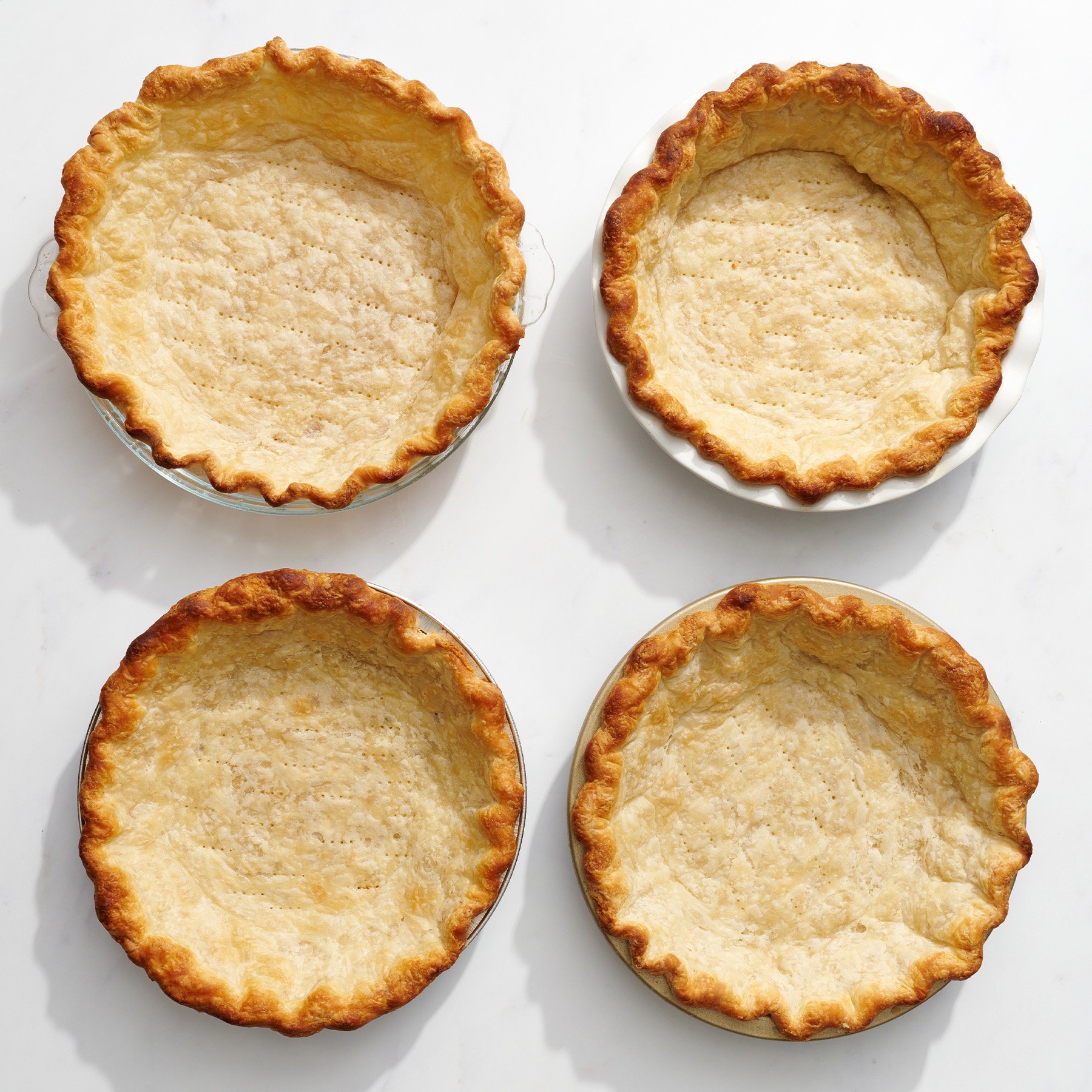 comparison of pie crusts baked in glass, ceramic, disposable, and metal pie pans