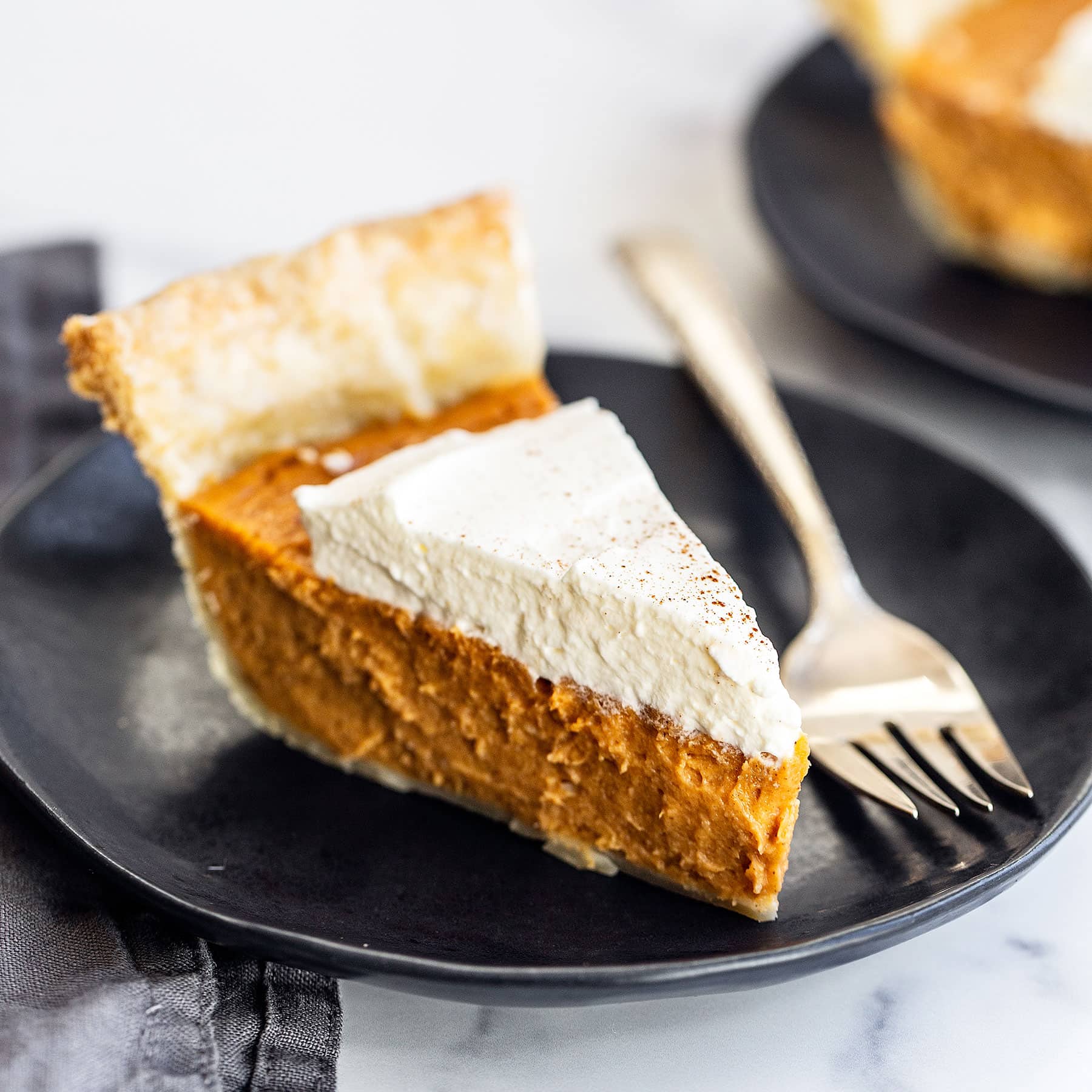 Slice of homemade brown butter sweet potato pie on a plate with a fork