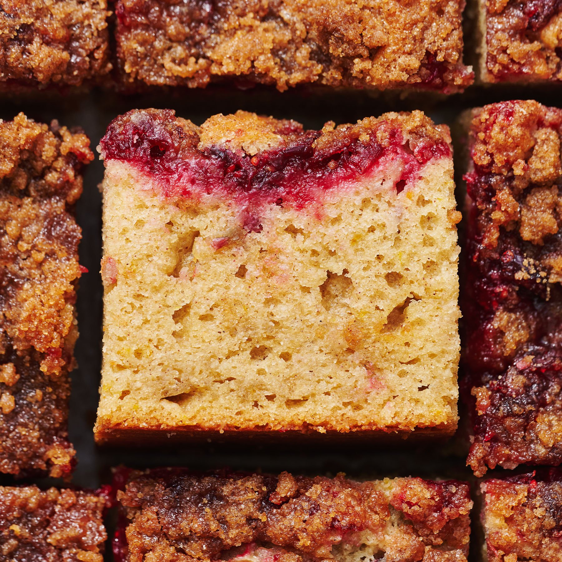 slice of cranberry orange coffee cake surrounded by other slices of coffee cake