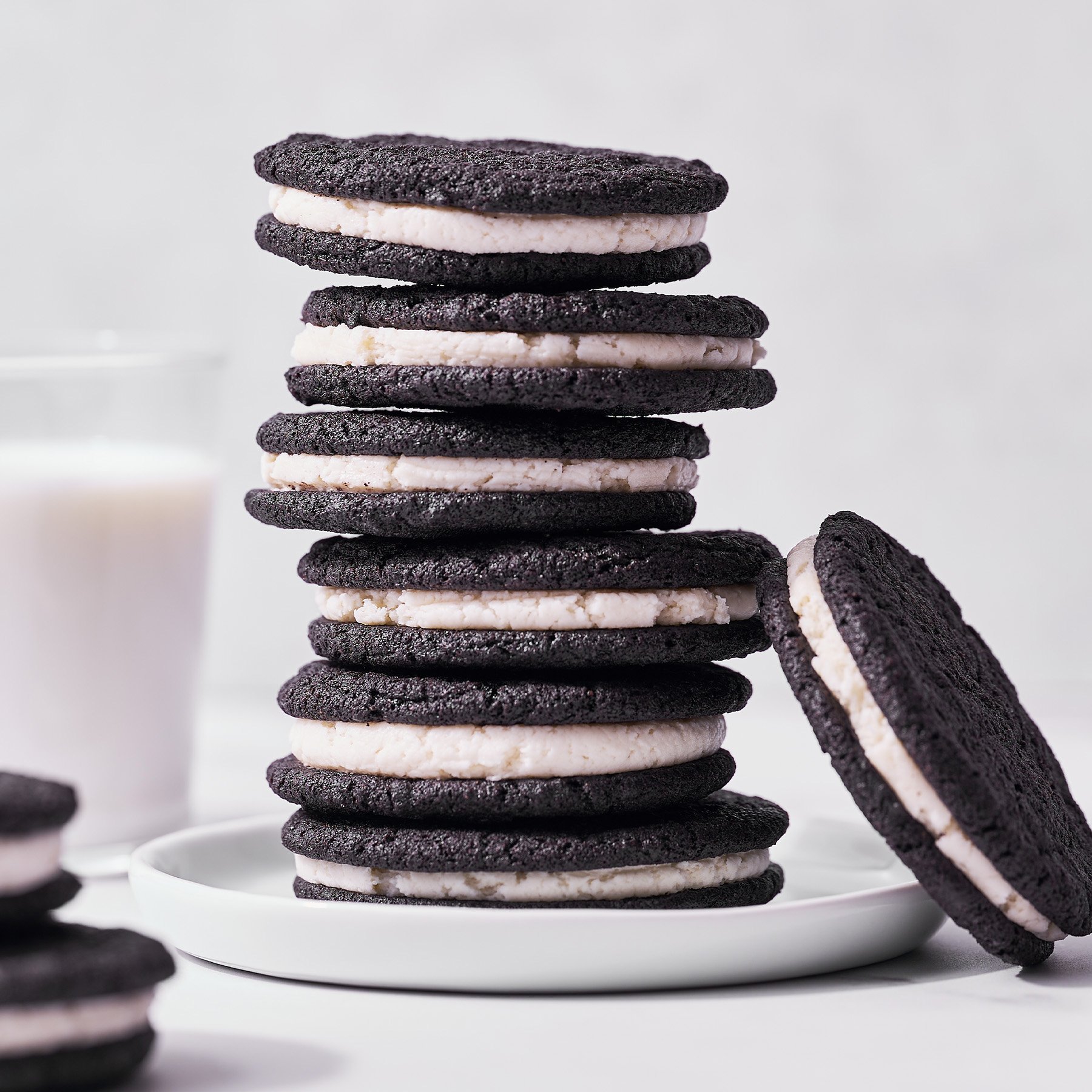 stack of homemade oreo cookies with a glass of milk