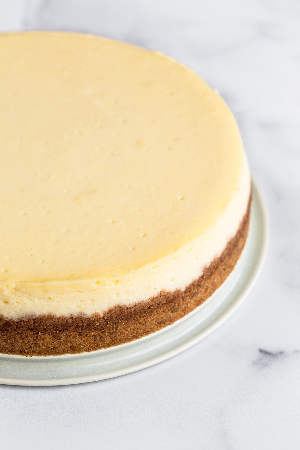 perfectly smooth and creamy cheesecake with no cracks and a graham cracker crust