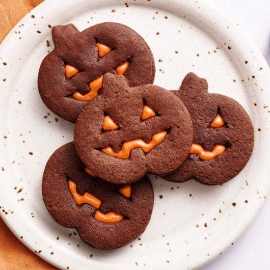 easy homemade jack o lantern cookies on a plate with an orange towel