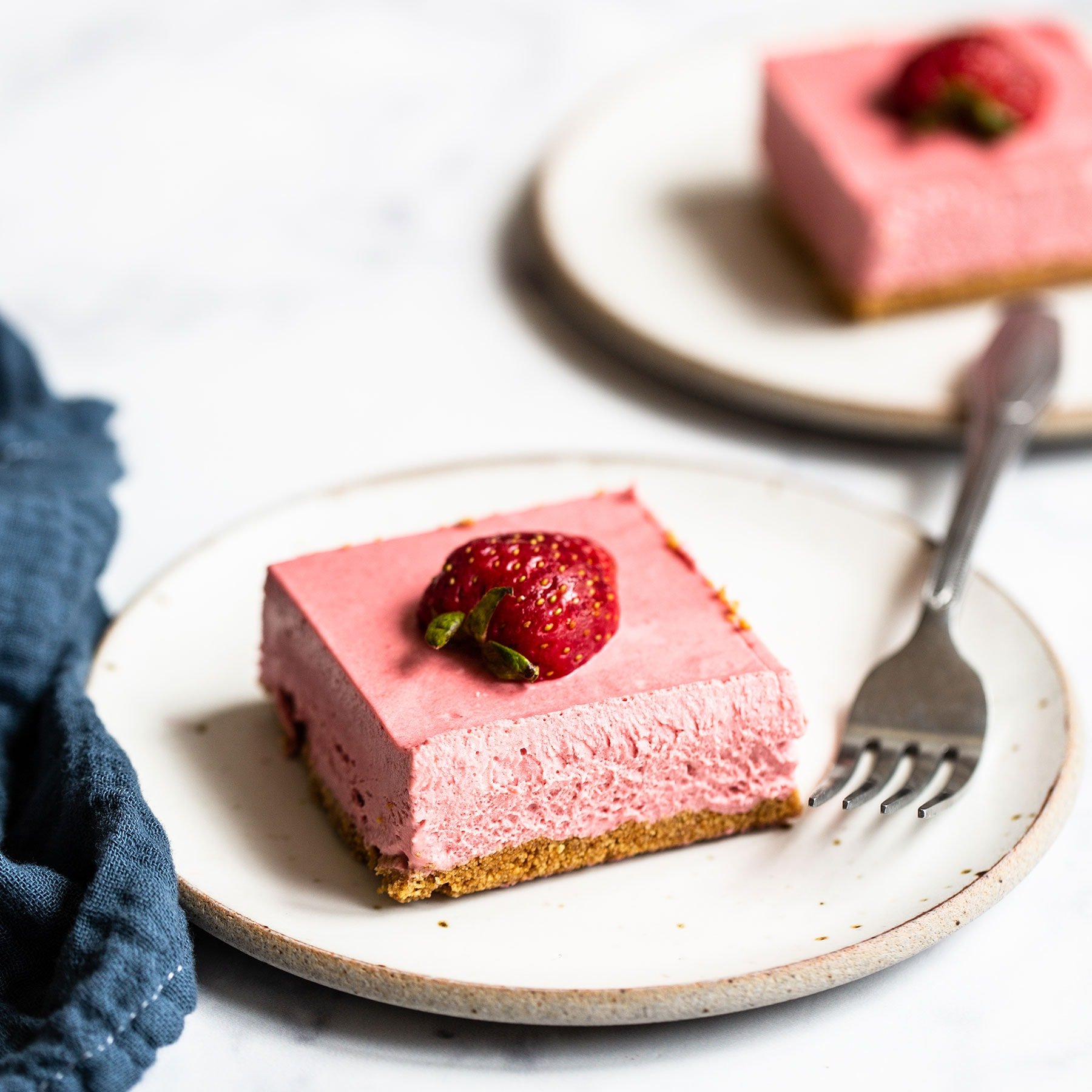 No Bake Strawberry Cheesecake Bars plated with fork and napkin