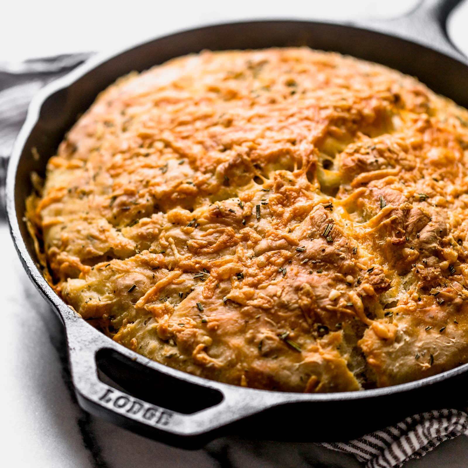 No Knead Rosemary Parmesan Skillet Bread features a super easy homemade dough that comes together in a matter of minutes! This bread has tons of flavor and a crispy cheesy crust.
