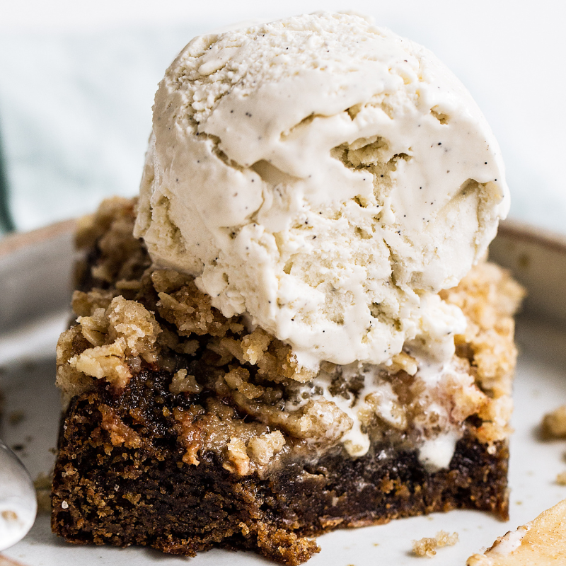 a square of apple crisp cookie bar with vanilla bean ice cream on top