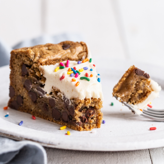a thick slice of Chocolate Chip Cookie Cake on a plate with a fork